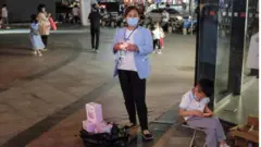 A vendor holds a tory sell at her street stall in Beijing, China, 05 June 2020. China turns to street vendor economy to help manage unemployment crisis that the COVID-19