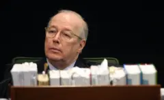 Celso de Mello sentando em frente a livros