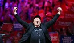 Elon Musk com as duas mãos levantadas