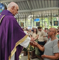 Padre Julio celebrando missa e interagindo com uma fiel