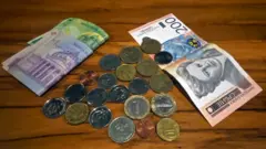 Rumunske, hrvatske, albanske, bugarske, makedonske i mađarske kovanice na stolu, sa paprirnim dinarima i rumunskim lejima