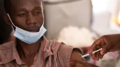 Un professionnel de la santé se fait vacciner contre le COVID-19 à Kampala, en Ouganda.