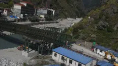 ल्हेन्दे खोलामा बेलिब्रिज राख्ने क्रममा पुल केही लच्किएपछि नदीको बीचमा समेत पिलर राखिँदै गरेको बताइएको छ