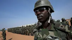 Newly arrive Nigerian protection force peacekeepers dey serve wit di African Union Mission for Sudan (AMIS) dey listen to address by di mission commander General Martin Luther Agwai (no dey di foto) for di Mission Group Site (MGS) for Graida, southern Darfur, 24 October 2007