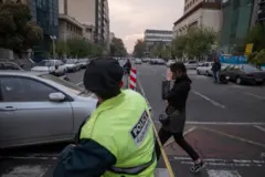 دختری بدون حجاب اجباری در حال عبور از مقابل یک مامور پلیس