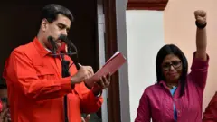 Delcy Rodríguez com o braço levantado, ao lado de Nicolás Maduro, em 2019