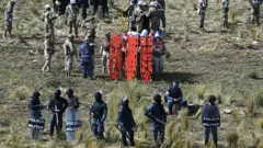 Policías y fuerza militar protegen el lugar del accidente.