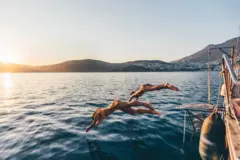 Duas mulheres saltando de barco no mar