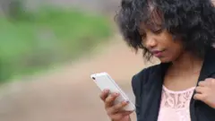 Foto of woman wey dey look her fone