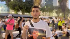 يوسف قدح يحمل صورة ابن خاله الذي قتل بسبب الجريمة