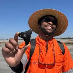 Um membro da equipe da Charleston Fossil Adventures exibindo um objeto encontrado em um naufrágio