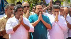 විමල් සහ ගම්මන්පිල ඇතුළු පිරිසක් සිටින ඡායාරූපයකි