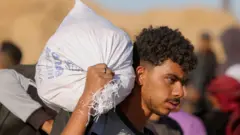  ባለፈው ወር በኻን ዩኒስ አንድ ፍልስጤማዊ የእርዳታ እህል ተሸክሞ 