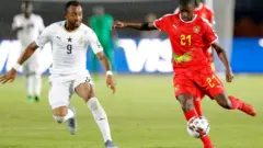 Le défenseur de la Guinée-Bissau Nanu Gomes (à droite) est marqué par l'attaquant ghanéen Jordan Ayew
