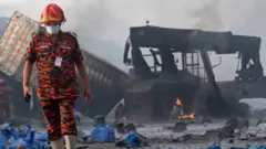 A rescuer walks through the debris of the fire