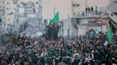 مقاتلون من حماس يرافقون سيارة تابعة للصليب الأحمر لنقل الرهائن الثلاثة المفرج عنهن، -وحول المقاتلين أعداد كبيرة من الغزيين-، بعد سريان اتفاق وقف إطلاق النار بين إسرائيل وحماس، في غزة الأحد 19 يناير/كانون الثاني 2025.