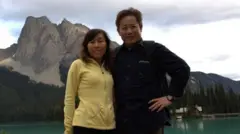Чэнь Юлинь (справа) и его жена Жун Юйфан позируют для фотографии на фоне гор и озера
