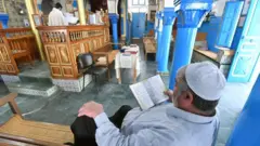 Homens judeus tunisianos rezam em uma sinagoga em Djerba, durante a peregrinação anual judaica