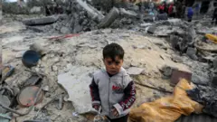 一名巴勒斯坦男孩站在被空襲後的加沙廢墟中