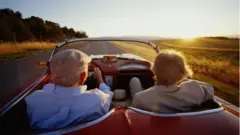 Older couple in open top car