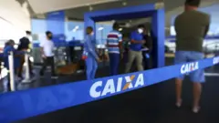 Pessoas entrando em agência da caixa