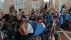 Penduduk setempat menunggu kereta evakuasi di Kherson.