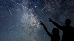 Dos personas observando lluvia de meteoros