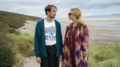 Cena do filme 'The Ballad of Wallis Island' mostra homem e mulher na praia