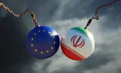 تصميم لكرتين مزينتين بعلم الاتحاد الأوروبي وعلم إيران فوق سماء عاصفة داكنة