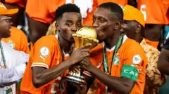 Awọn agbabọọlu Ivory Coast meji, Simon Adingra ati Max-Alain Gradel di ife ẹyẹ Afcon mu pẹlu idunnu