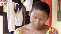 Nwaanyị bọrọ isi ya na-ele anya n'ala