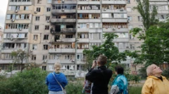 Abatuye mu murwa mukuru Kyiv wa Ukraine bararamye bareba ku nyubako y'amacumbi yangiritse nyuma y'igitero cya 'drone' cy'Uburusiya