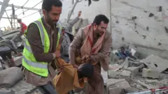Una captura de pantalla de un video muestra a paramédicos transportando a un migrante africano herido en un centro de detención.