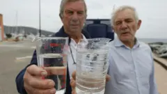 ২০২২ সালে ইতিহাসের অন্যতম শুষ্ক গ্রীষ্মের পর চালু হওয়া একটি লবণমুক্তকরণ প্ল্যান্টের সামনে ফ্রান্সের গ্রামীণ মেয়ররা।