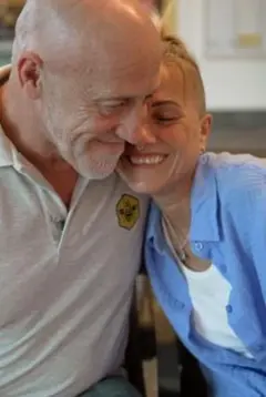 Dave Green y Andrea Urmston abrazándose y sonriendo.