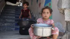 Девочка с кастрюлей на ступеньках дома в Газе