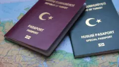 Dünya haritasının üzerine koyulmuş biri bordo diğeri yeşil pasaport olmak üzere iki Türkiye pasaportu görülüyor. 