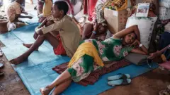 Ethiopian refugees who fled the Tigray conflict, rest in a makeshift shelter at Um Raquba reception camp in Sudan's eastern Gedaref state, on 3 December 2020