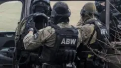 Правоохоронці у формі сідають в автомобіль 