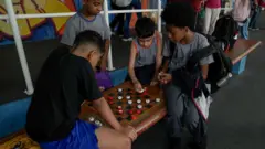 Niños juegan ajedrez en la escuela pública.
