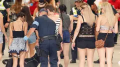 A police officer uses a sniffer dog to test festival goers in Melbourne