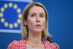 كايا كالاس بشرتها بيضاء ترتدتي قميصاً ملوناً بالوردي والبرتقالي والأبيض.