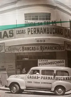 Carro parado em frente a uma loja escrito Casas Pernambucanas