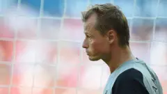 Алекс Меннінгер у профіль на тлі сітки воріт