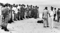 جنود ورجال إنقاذ غابونيون عند شاطئ ليبرفيل بعد سقوط طائرة منتخب زامبيا في المحيط الأطلسي، في 28 أبريل/نيسان 1993 