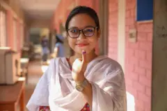 बाङ्ग्लादेशमा मतदान गरेपछि औँलामा लगाइएको मसी देखाउँदै एक महिला