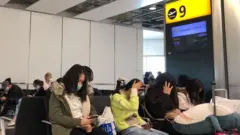 Các hành khách Việt Nam đang chờ ở sân bay Anh để về nước
