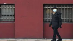 Kore'de maske takan bir kişi