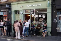 Clientes se sentam do lado de fora de um café Blank Street Coffee no Soho