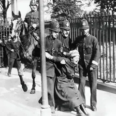 Manifestante a favor do voto feminino no Reino Unido por volta de 1910 sendo arrastada por três policiais